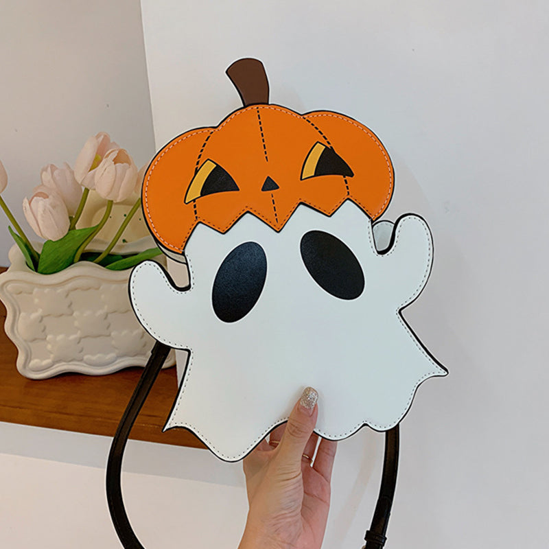 Front view of the white ghost-shaped bag with an orange pumpkin hat held in one hand.