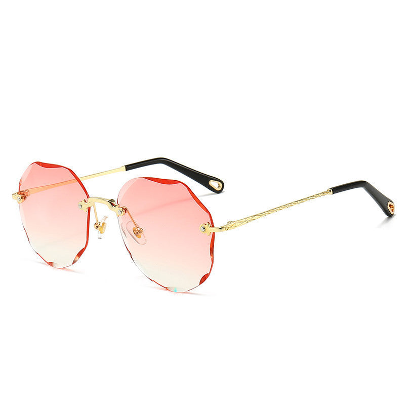 One pair of rimless polygonal sunglasses with red gradient lenses and gold-tone temples on white