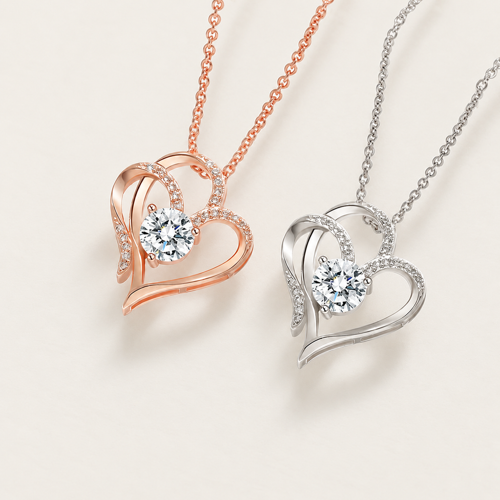 Rose-gold-tone and silver-tone open-heart pendant necklaces with clear center stones on ivory