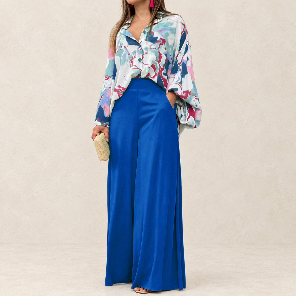 Cobalt-blue high-waist wide-leg trousers worn by a model against an ivory studio backdrop