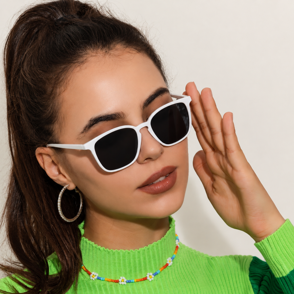 Woman wearing white-framed dark sunglasses against a warm ivory background