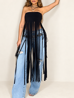 Black bandeau top with long fringe worn over jeans against an ivory background