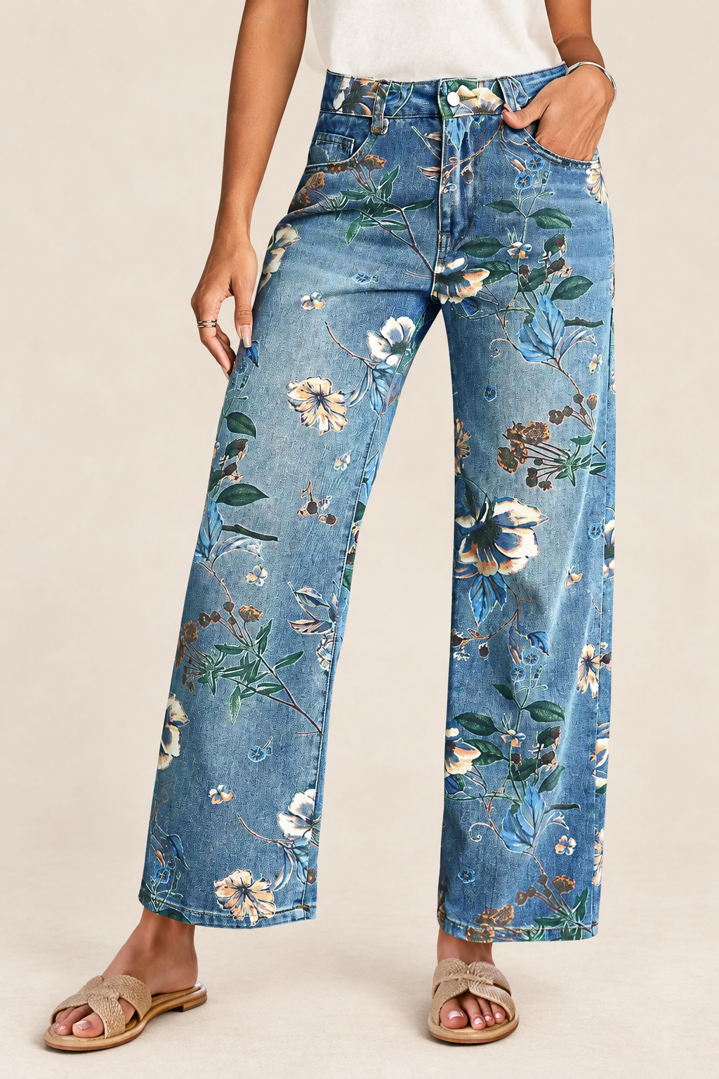 Light-blue floral-print wide-leg jeans worn by a model with beige sandals against an ivory background