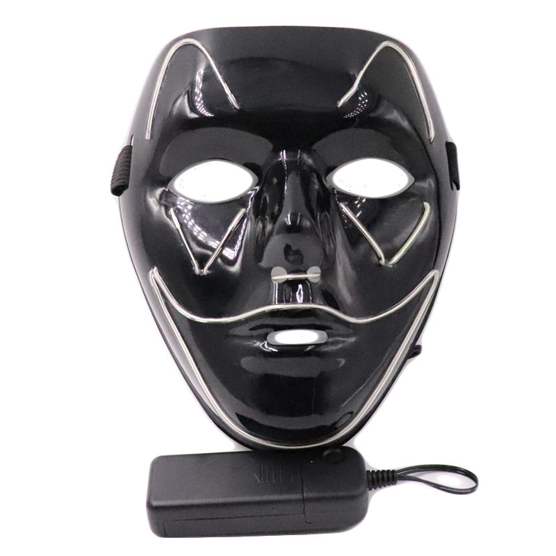 Black costume mask with a curved smile outline and wired controller, shown with the lights off.