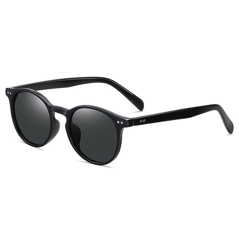 Black round-frame sunglasses with dark lenses and small silver-tone temple studs
