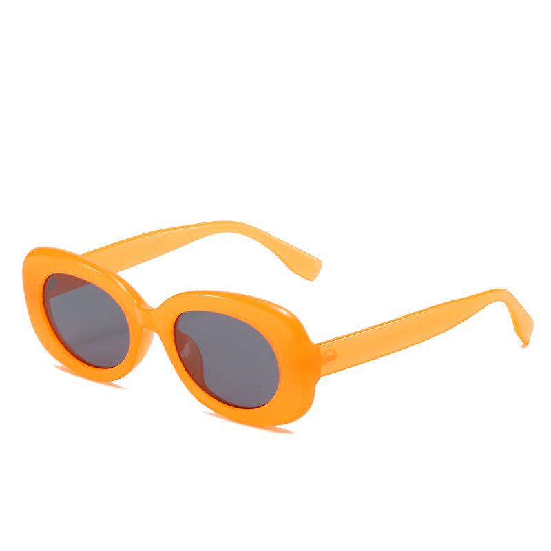 Orange oval sunglasses with dark lenses on white.