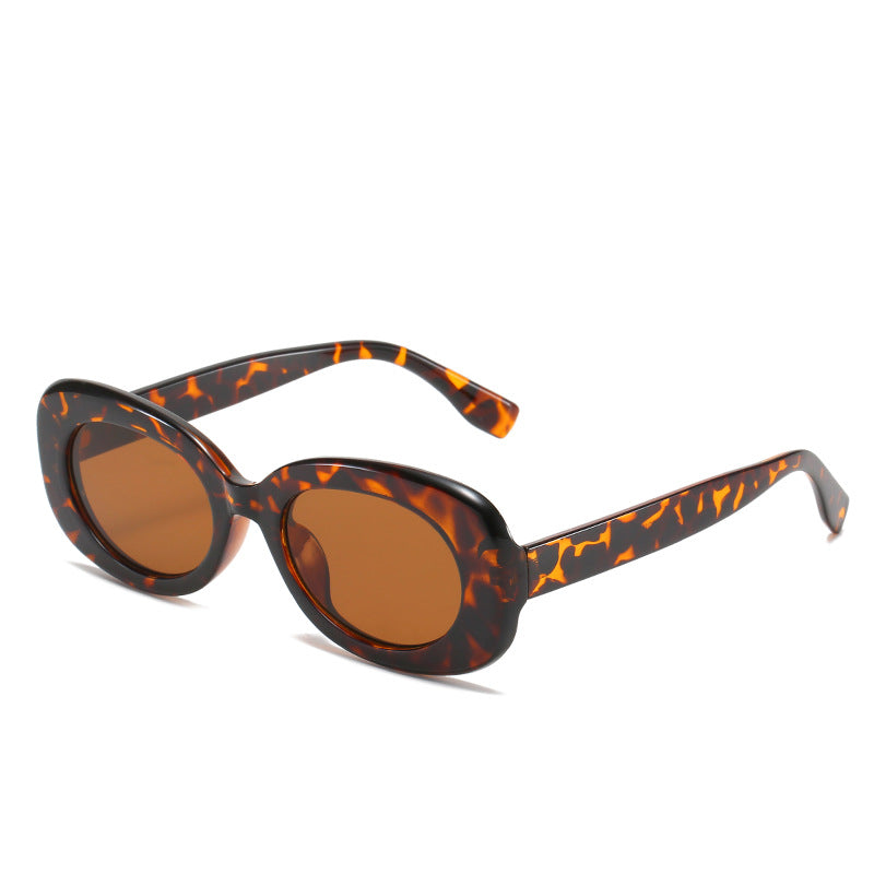Tortoiseshell oval sunglasses with brown-tinted lenses on white.