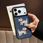 Phone case with a navy-blue textured panel and two white dog motifs with red collars, held in a hand