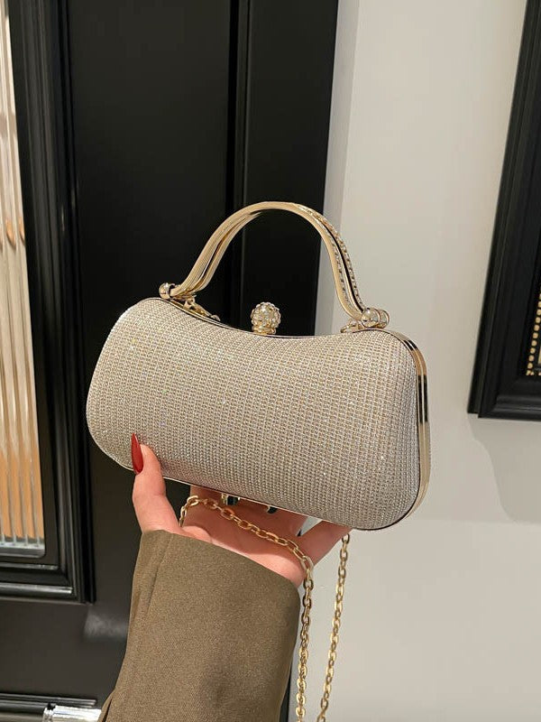 Gold-tone evening bag with a curved top handle, round top detail and chain strap, held view