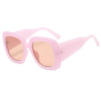 Pale pink oversized square sunglasses with peach-tinted lenses on a white background