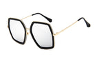 Oversized geometric glasses with a black frame, clear lenses and gold-tone arms on a white background