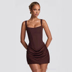 Model wearing a dark brown sleeveless fitted mini dress with a draped skirt