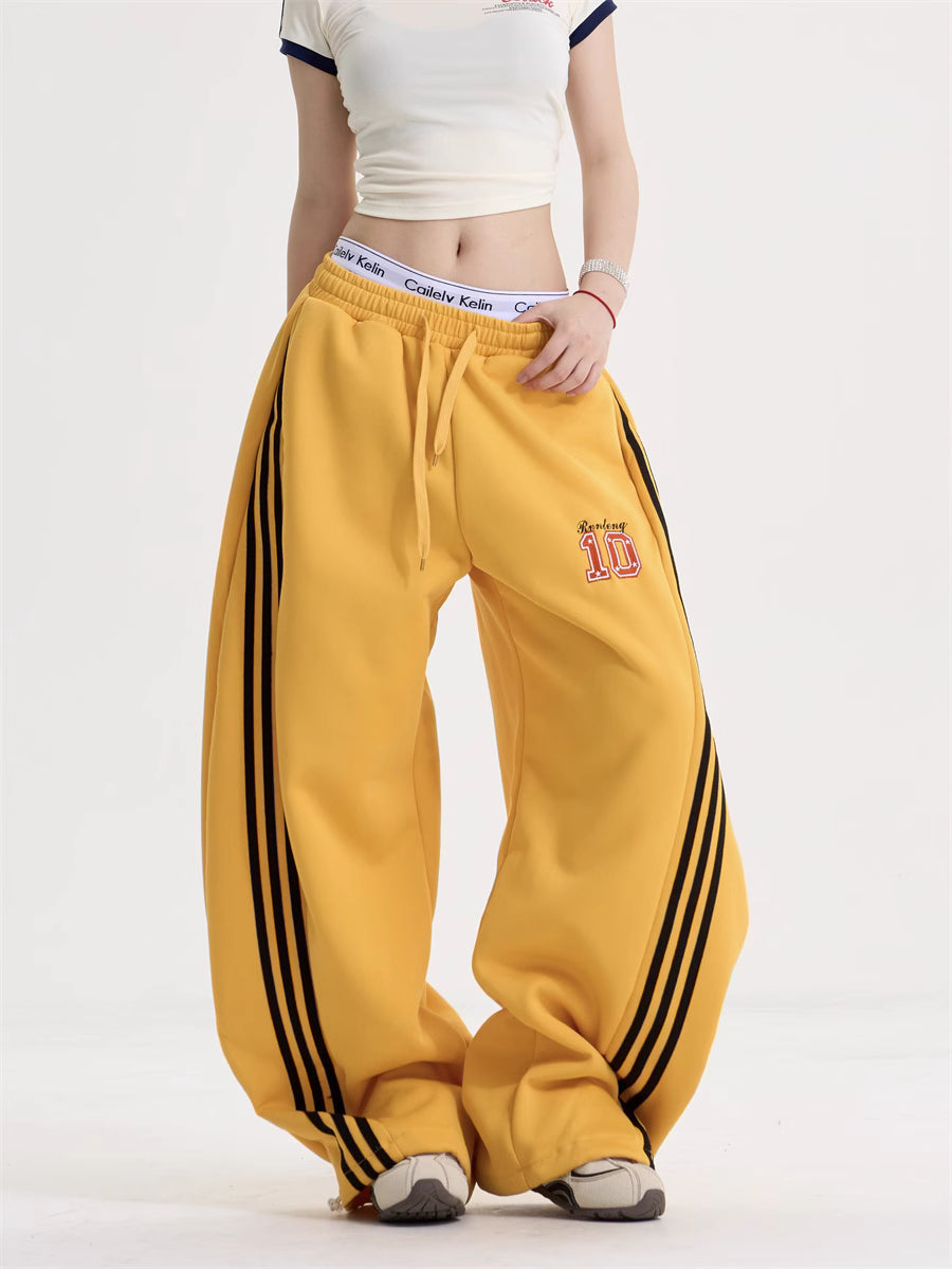 Yellow wide-leg trousers with black side stripes, a drawstring waist and a number 10 motif.