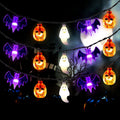Purple bat, orange pumpkin and white ghost string lights in an illustrative display