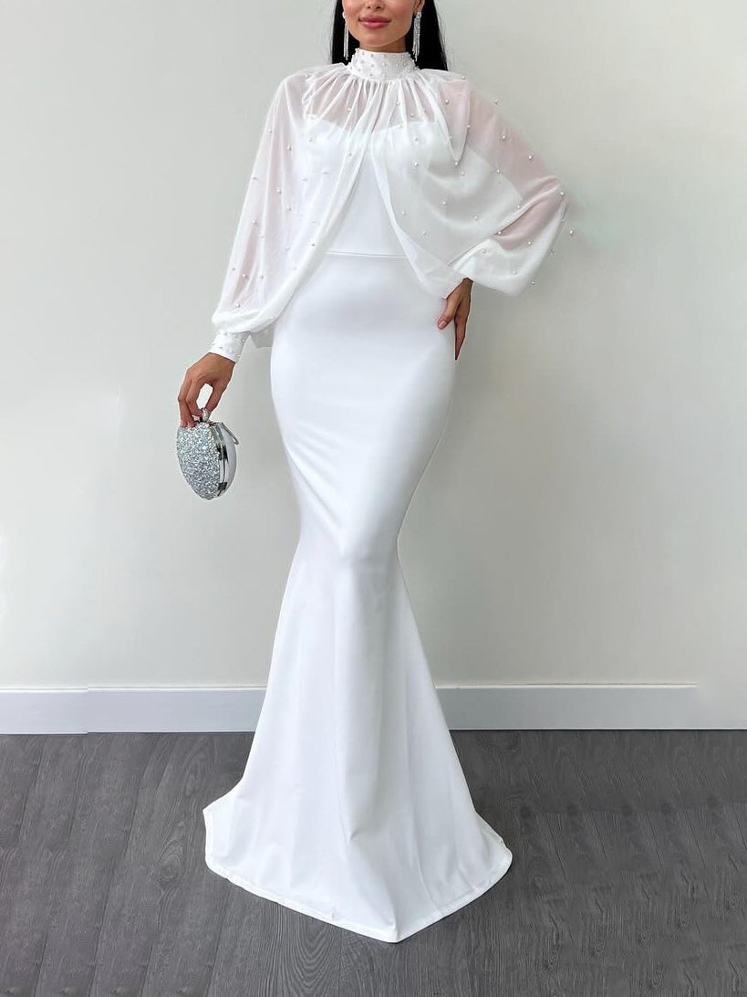 Model wearing a white dress with a beaded sheer high-neck long-sleeve top; clutch and jewellery are styling accessories