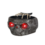 Gray skull candy bowl with skeleton hand and illuminated eyes