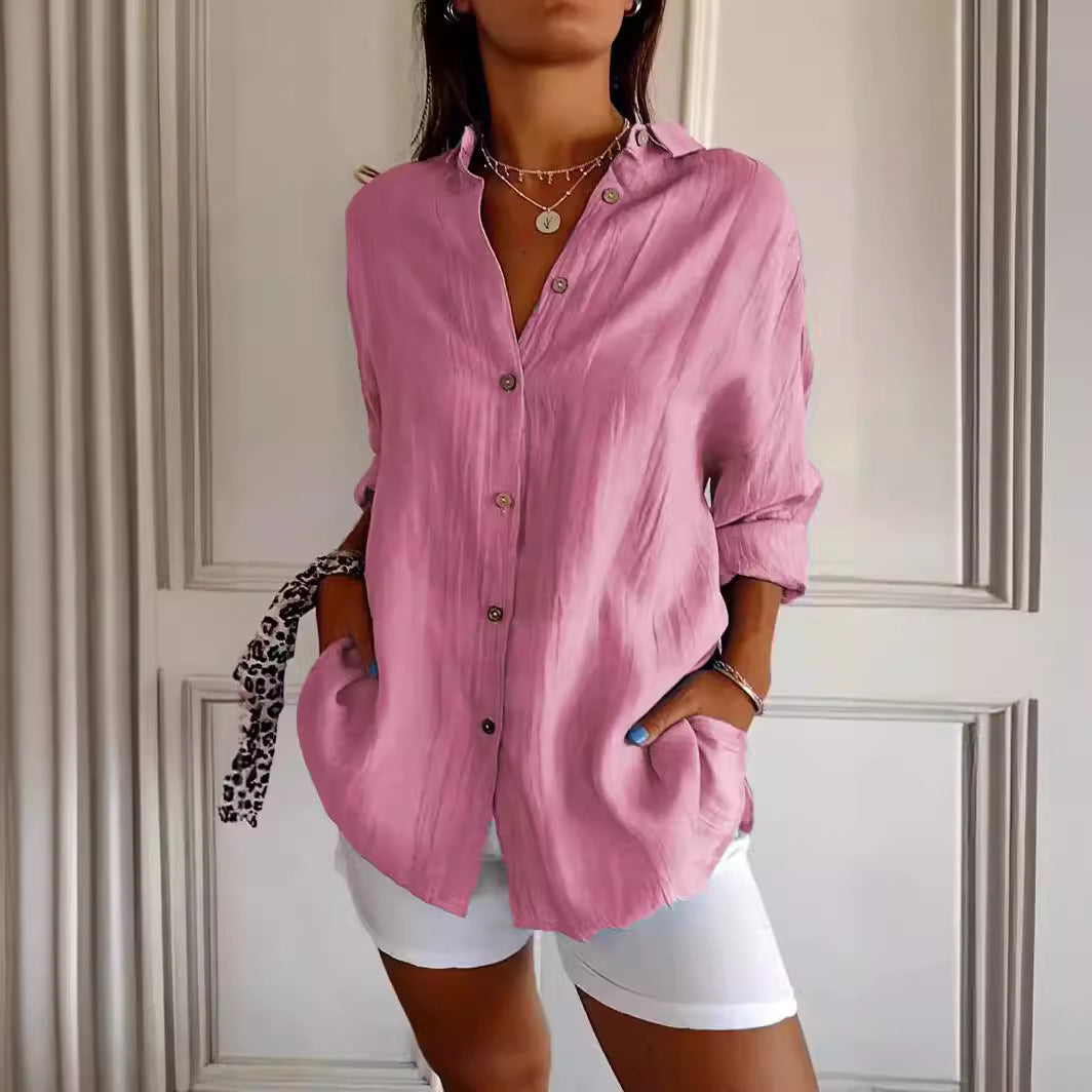 Pink collared button-front shirt with rolled sleeves and a curved hem.