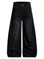 Black washed jeans with curved wide legs, metal eyelet rows and front pockets, shown on white