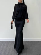 Model wearing a black dress with a beaded sheer high-neck long-sleeve top; clutch and jewellery are styling accessories