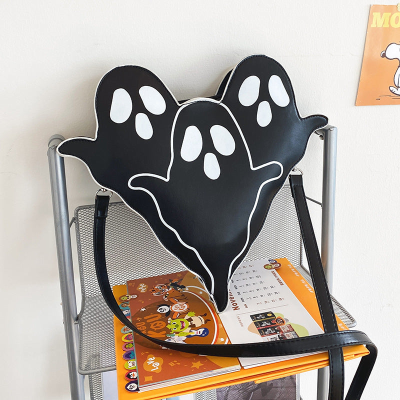 Black Ghost Crossbody Bag displayed on a chair with its shoulder strap.