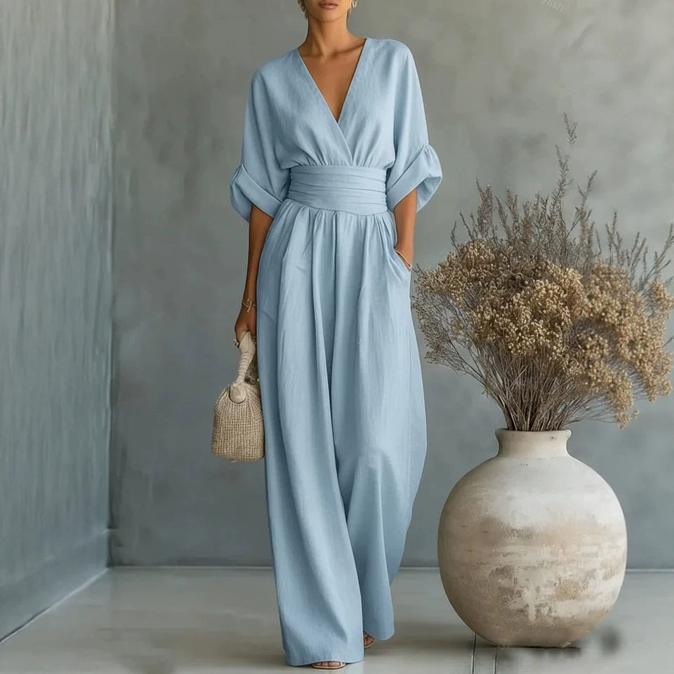 Light blue V-neck wide-leg jumpsuit with short sleeves and a gathered waist, shown worn.