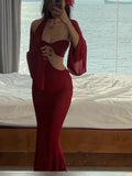 Model wearing a red cutout dress with long flared sleeves in a mirror photograph