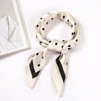 Beige scarf with black polka dots and a black border, shown knotted