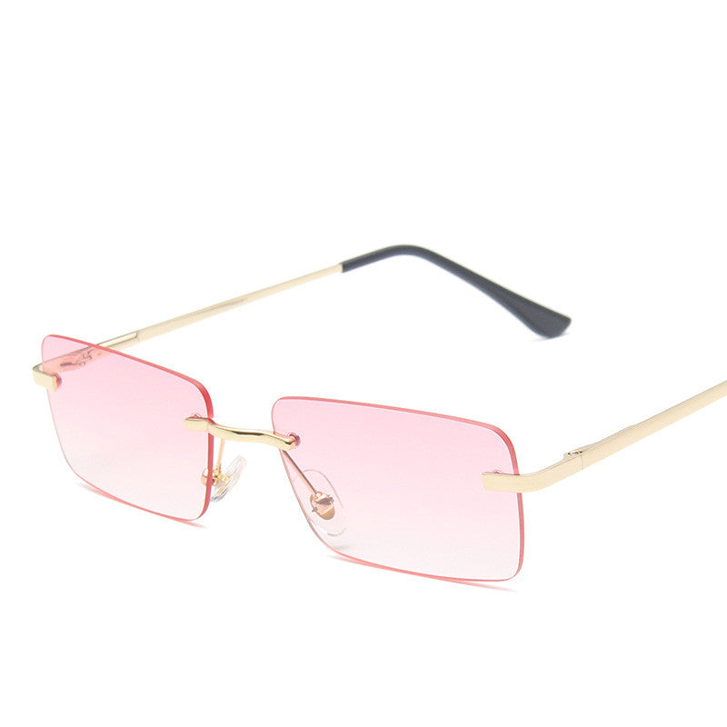 Rectangular rimless sunglasses with pink lenses and gold-tone arms on a white background