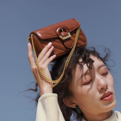 Brown Chain Detail Shoulder Bag held above the head