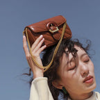 Brown Chain Detail Shoulder Bag held above the head