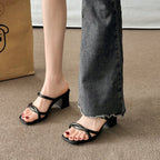 Black square-toe sandals with crossed front straps and block heels.