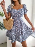 Blue floral mini dress with short puff sleeves and a flared skirt, shown worn from the front.