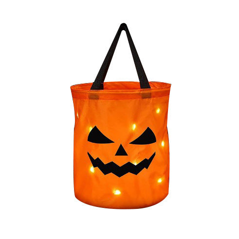Orange jack-o'-lantern candy bag with a frowning face and black handle, shown with glowing points on white.