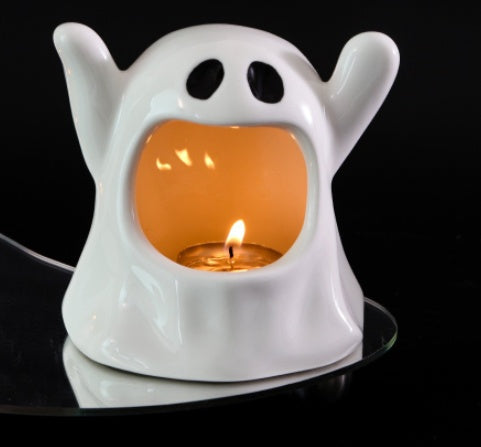 White ghost-shaped ceramic candle holder shown with a lit display tealight