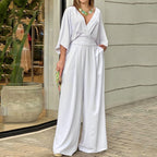 White V-neck wide-leg jumpsuit with loose sleeves and a gathered waist, shown worn.