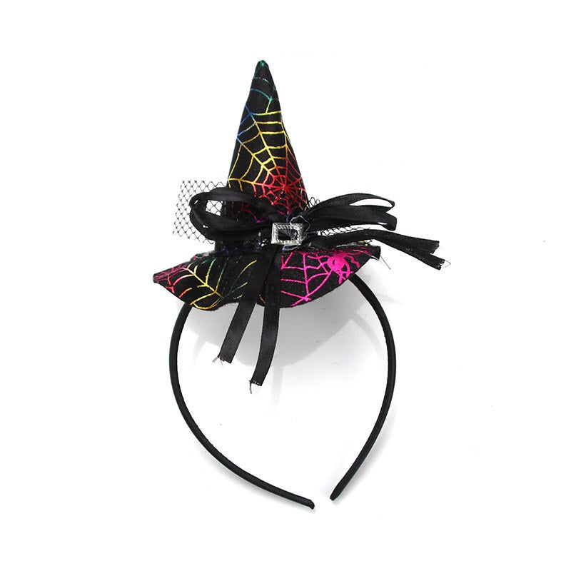 Black headband topped with a miniature witch hat in a multicolour spiderweb print, black bow, netting and silver-colour buckle.