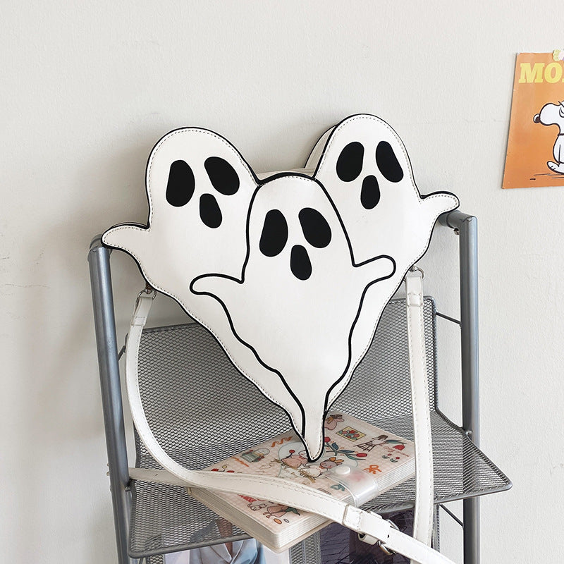 White Ghost Crossbody Bag displayed on a chair with its shoulder strap.