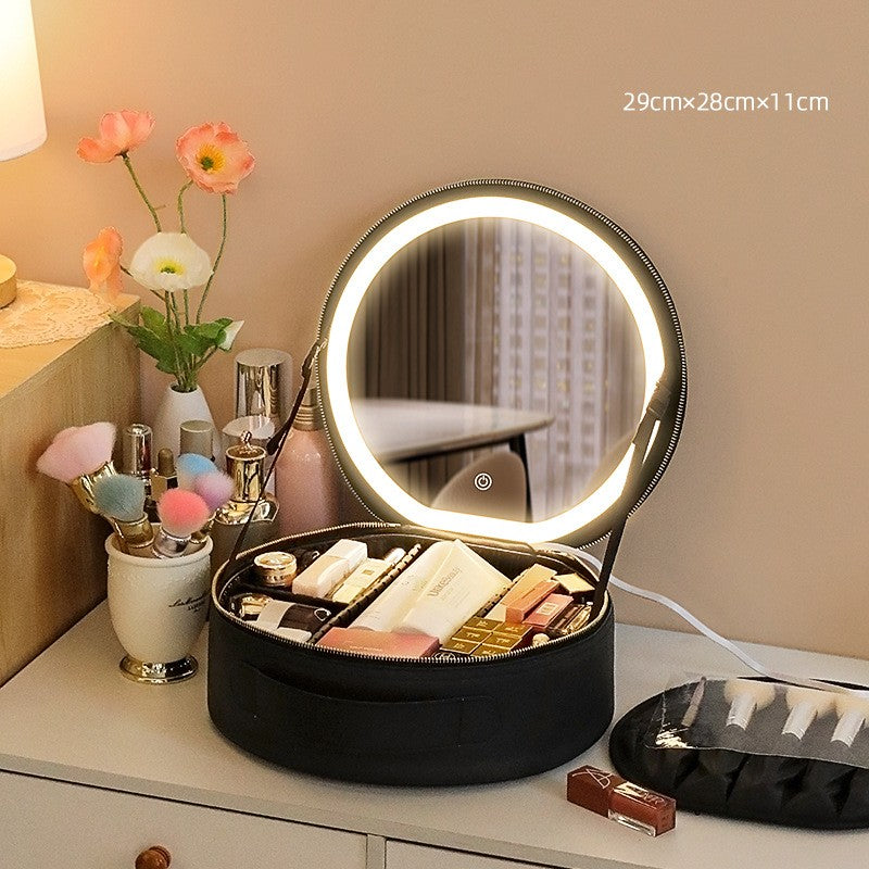 Black round makeup case shown open with an illuminated mirror and cosmetics pictured in its compartments.