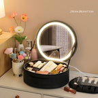 Black round makeup case shown open with an illuminated mirror and cosmetics pictured in its compartments.
