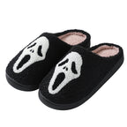 Pair of black slippers with white ghost-face motifs and pale pink lining