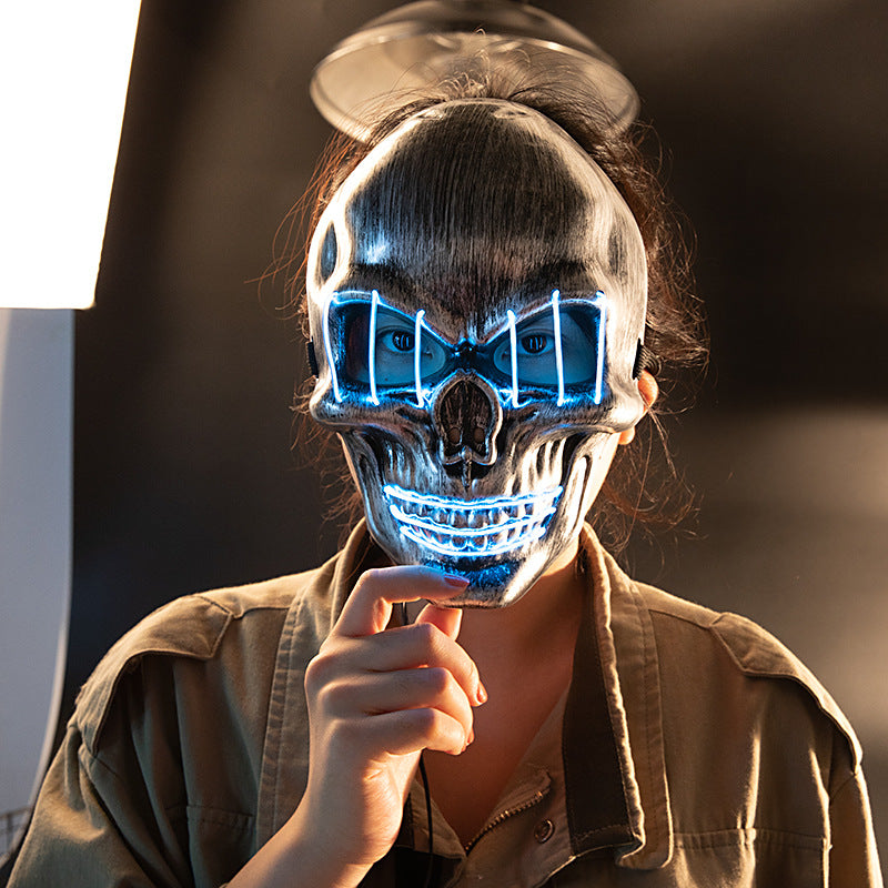 Silver-colour skull costume mask with blue illuminated lines, shown worn
