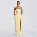 Model wearing a pale yellow strapless pleated gown with a high slit
