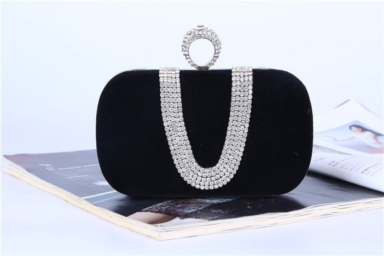 Black velvet evening clutch with a rhinestone loop clasp and draped rhinestone trim