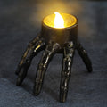 One skeleton-hand LED candle decoration shown illuminated.