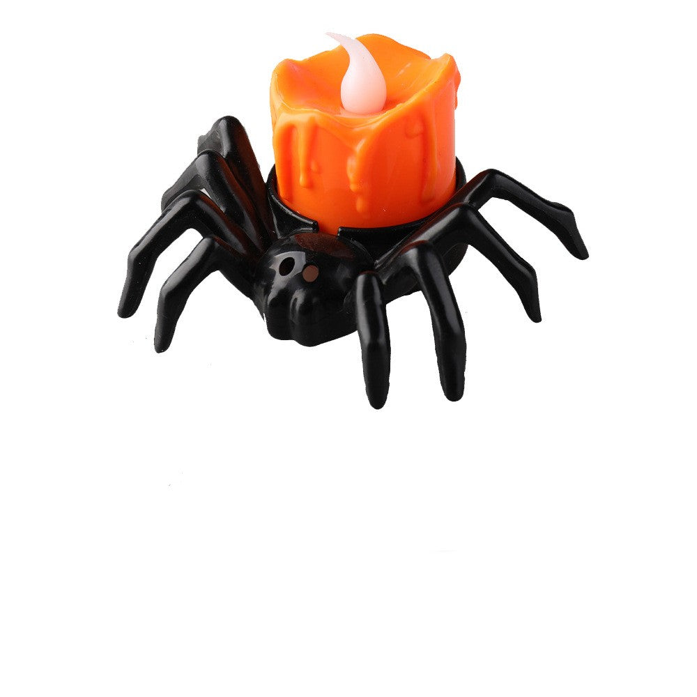 Single black spider-shaped decorative lamp with an orange candle-shaped top and a white flame-shaped tip on a white background.