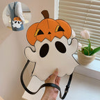 White ghost-shaped crossbody bag with an orange pumpkin hat, shown in a hand with a circular on-body inset.