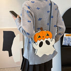 White ghost-shaped bag with an orange pumpkin hat worn at the hip over a grey cardigan.