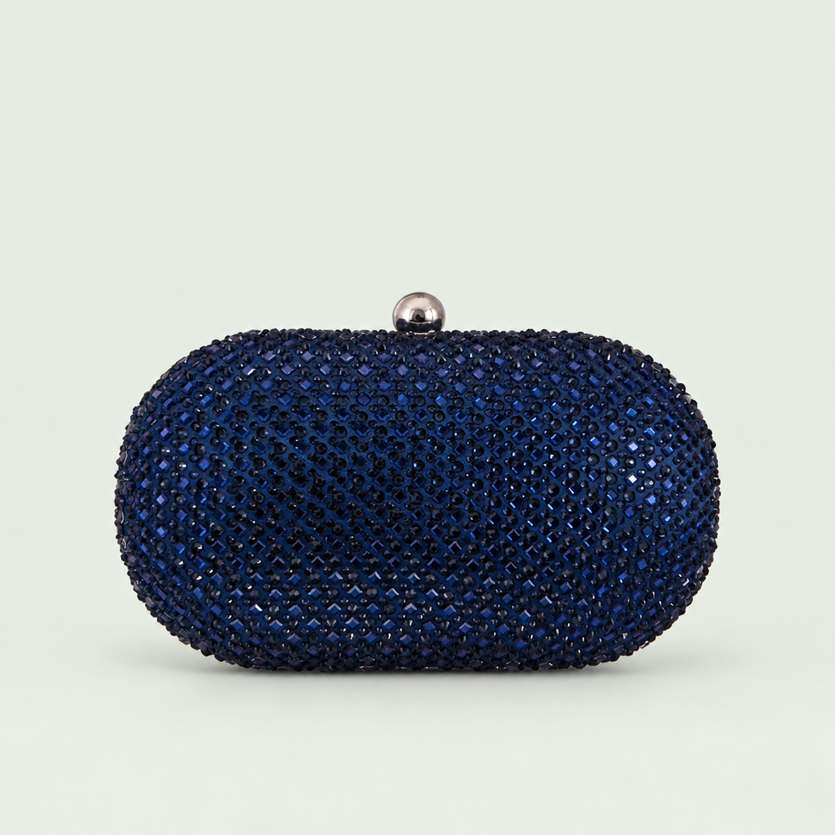 Embellished Oval Clutch in Dark Blue on a pale sage background