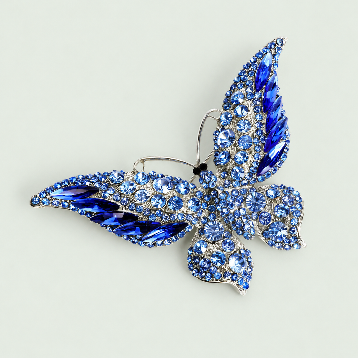 Statement Butterfly Brooch in Blue on a pale sage background